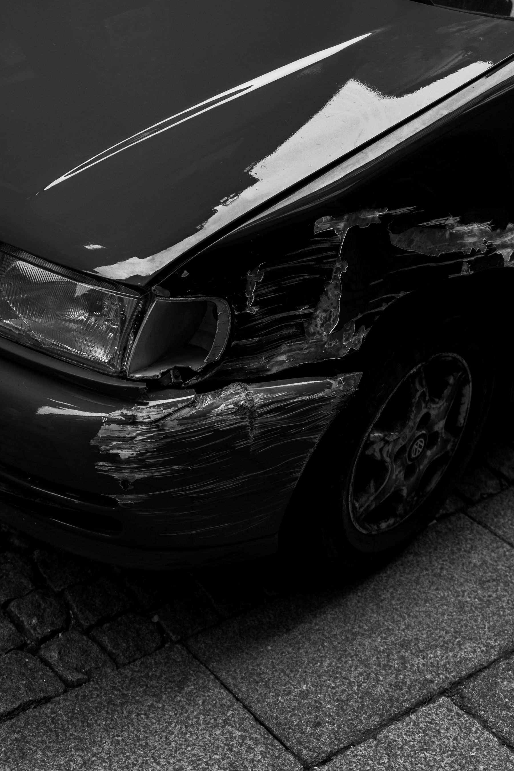 Black and white close-up of a scratched car front